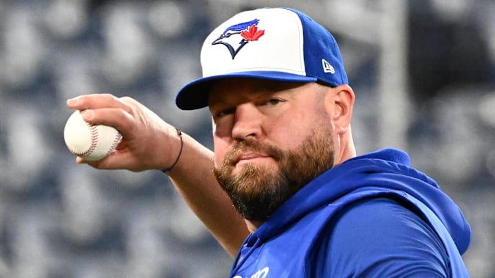 Toronto Blue Jays manager John Schneider (14) throws the ball during workouts for the American League Championship Series at Rogers Centre. Toronto Blue Jays manager John Schneider (14) throws the ball during workouts for the American League Championship Series at Rogers Centre.