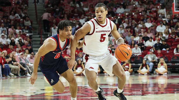 Nov 14, 2025; Fayetteville, Arkansas, USA; Arkansas Razorbacks guard Darius Acuff Jr (5) drives against Samford Bulldogs guard Isaiah Campbell-Finch (0) during the second half at Bud Walton Arena. Arkansas won 79-75.