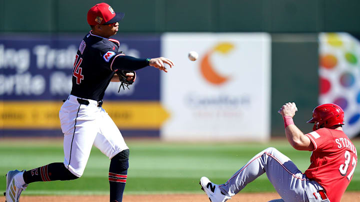 Cleveland Guardians second baseman Juan Brito (74) tags out Cincinnati Reds catcher Tyler Stephenson (37) in the first inning of a Cactus League game between the Cincinnati Reds and Cleveland Guardians, Saturday, Feb. 21, 2026, at Goodyear Ballpark in Goodyear, Ariz.