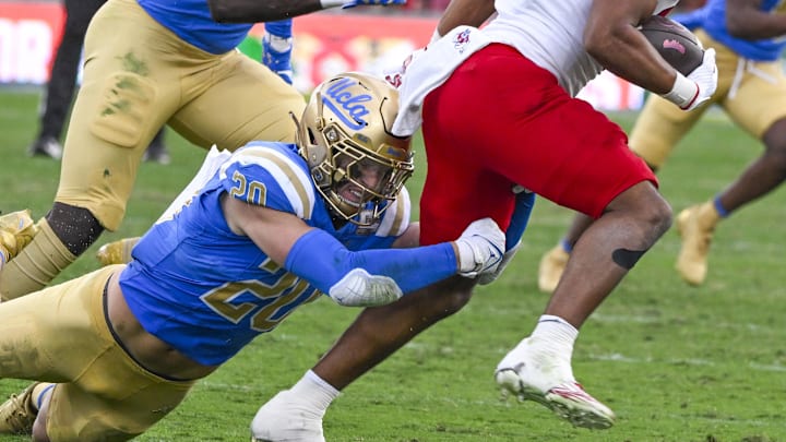Nov 30, 2024; Pasadena, California, USA; UCLA Bruins linebacker Kain Medrano (20) tries to bring down Fresno State Bulldogs running back Bryson Donelson (26) during the third quarter at Rose Bowl. Mandatory Credit: Robert Hanashiro-Imagn Images