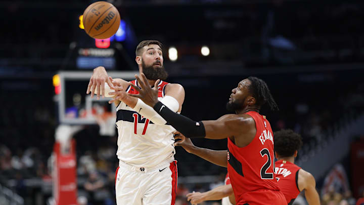 Oct 11, 2024; Washington, District of Columbia, USA; Washington Wizards center Jonas Valanciunas (17) passes the ball as Toronto Raptors guard Jamal Shead (23) defends in the second quarter at Capital One Arena. Mandatory Credit: Geoff Burke-Imagn Images