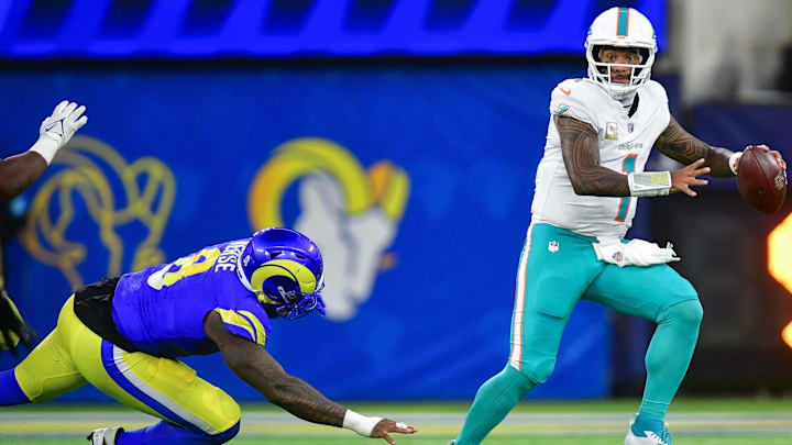 Miami Dolphins quarterback Tua Tagovailoa (1) moves out to pass as Los Angeles Rams linebacker Jared Verse (8) moves in during the second half at SoFi Stadium.