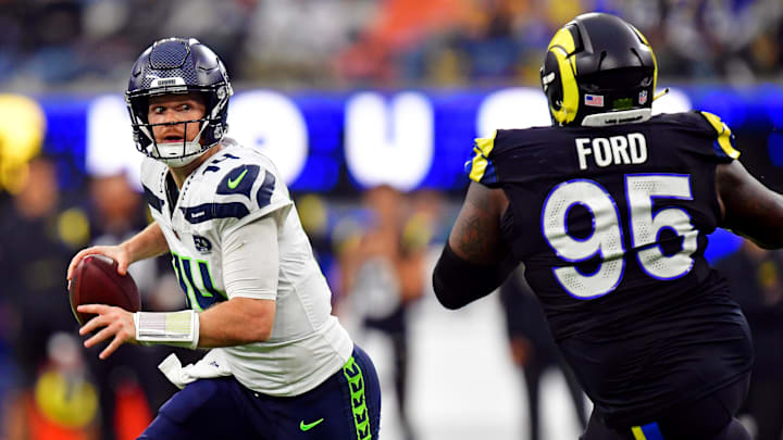 Nov 16, 2025; Inglewood, California, USA; Seattle Seahawks quarterback Sam Darnold (14) rolls out to pass against Los Angeles Rams defensive tackle Poona Ford (95) during the second half at SoFi Stadium. Mandatory Credit: Gary A. Vasquez-Imagn Images