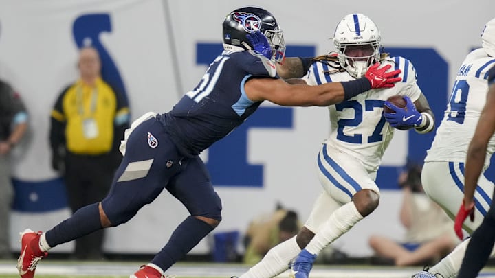 Dec 22, 2024; Indianapolis, Indiana, USA; Tennessee Titans linebacker Cedric Gray (51) reaches for Indianapolis Colts running back Trey Sermon (27) during a game against the Tennessee Titans at Lucas Oil Stadium. Mandatory Credit: Christine Tannous/USA Today Network via Imagn Images 