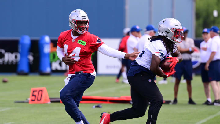 Jun 10, 2024; Foxborough, MA, USA;  New England Patriots quarterback Jacoby Brissett (14) hands the ball to running back Rhamondre Stevenson (38) at minicamp at Gillette Stadium. Mandatory Credit: Eric Canha-USA TODAY Sports