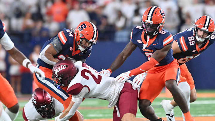 Sep 12, 2025; Syracuse, New York, USA; Syracuse Orange running back Will Nixon (24) is tackled by Colgate Raiders defensive back Reece Allan (23) in the first quarter at the JMA Wireless Dome. Mandatory Credit: Mark Konezny-Imagn Images