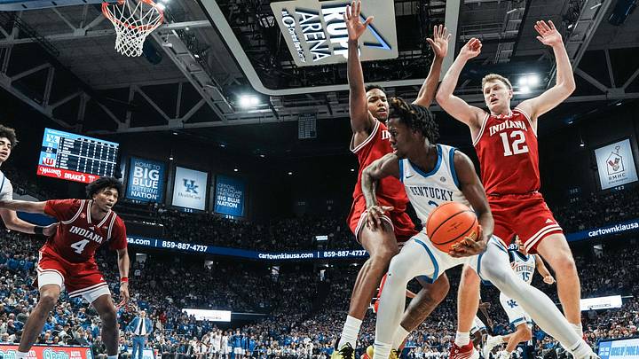 Kentucky Wildcats guard Kam Williams (3) tries to drive around Indiana Hoosiers forward Nick Dorn (7) and Indiana Hoosiers forward Tucker Devries (12) in the first half. The Cats beat the Hoosiers 72-60 during college basketball at Rupp Arena in Lexington, Kentucky December 13, 2025.