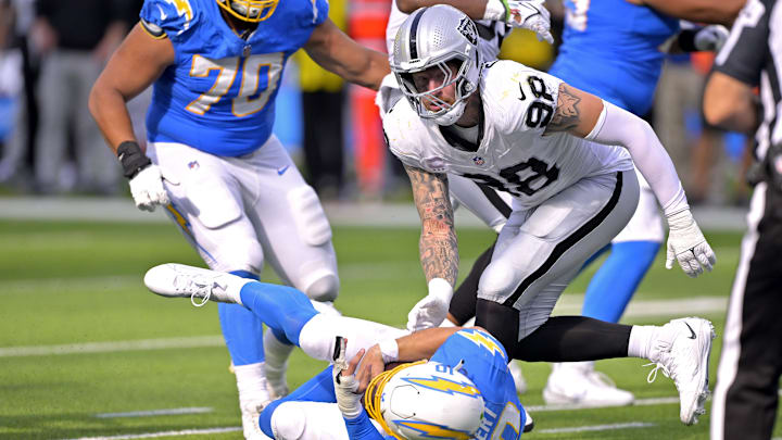 Oct 1, 2023; Inglewood, California, USA;  Los Angeles Chargers quarterback Justin Herbert (10) is sacked by Las Vegas Raiders defensive end Maxx Crosby (98) in the fourth quarter at SoFi Stadium. Mandatory Credit: Jayne Kamin-Oncea-Imagn Images