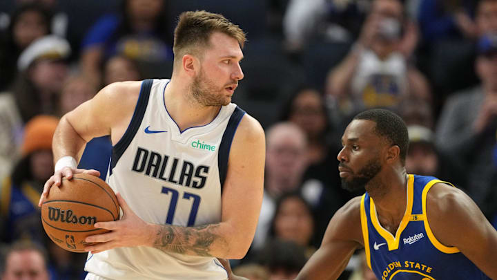 Dec 15, 2024; San Francisco, California, USA; Dallas Mavericks guard Luka Doncic (77) handles the ball against Golden State Warriors forward Andrew Wiggins (22) during the fourth quarter at Chase Center. Mandatory Credit: Darren Yamashita-Imagn Images