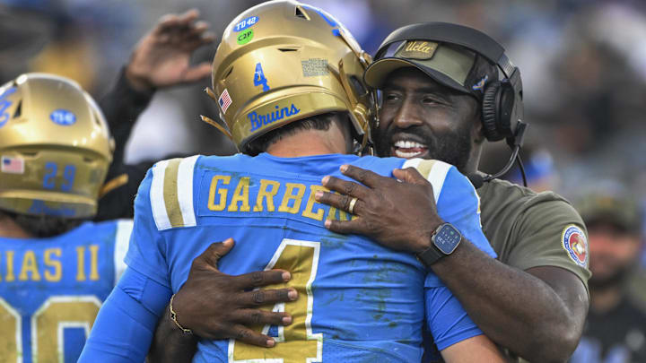 Nov 30, 2024; Pasadena, California, USA; UCLA Bruins head coach DeShaun Foster hugs quarterback Ethan Garbers (4) as time runs out during a Bruins victory over the Fresno State Bulldogs at Rose Bowl. Mandatory Credit: Robert Hanashiro-Imagn Images