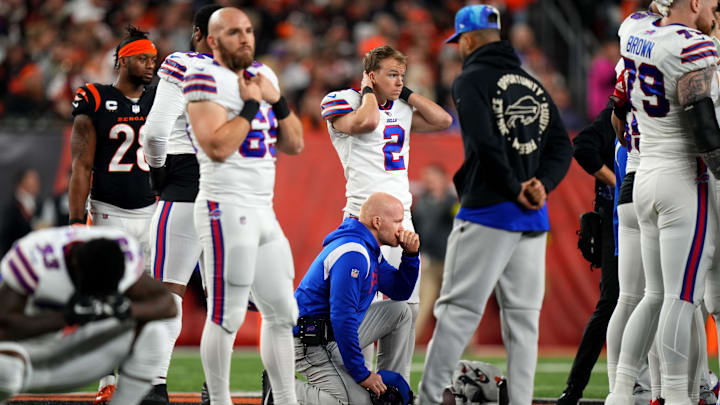 Buffalo Bills head coach Sean McDermott takes a knee as Buffalo Bills safety Damar Hamlin is tended to on the field following a collision in the first quarter of a Week 17 NFL game.