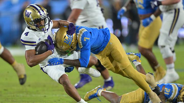 Nov 22, 2025; Pasadena, California, USA; Washington Huskies running back Jordan Washington (4) is stopped by UCLA Bruins defensive back Aaron Williams (7) after a gain of 17 yards and a first down during the second half at the Rose Bowl. Mandatory Credit: Jayne Kamin-Oncea-Imagn Images Nov 22, 2025; Pasadena, California, USA; Washington Huskies running back Jordan Washington (4) is stopped by UCLA Bruins defensive back Aaron Williams (7) after a gain of 17 yards and a first down during the second half at the Rose Bowl. Mandatory Credit: Jayne Kamin-Oncea-Imagn Images