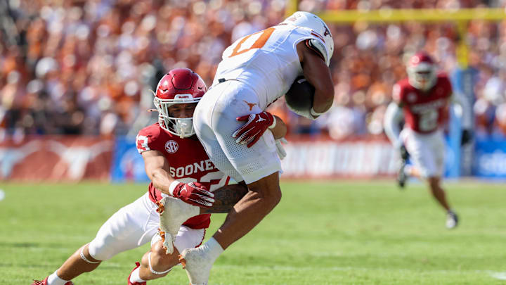 Oct 12, 2024; Dallas, Texas, USA; Oklahoma Sooners defensive back Eli Bowen (23) tackles Texas Longhorns wide receiver DeAndre Moore Jr. (0) during the game at the Cotton Bowl. Mandatory Credit: Kevin Jairaj-Imagn Images Oct 12, 2024; Dallas, Texas, USA; Oklahoma Sooners defensive back Eli Bowen (23) tackles Texas Longhorns wide receiver DeAndre Moore Jr. (0) during the game at the Cotton Bowl. Mandatory Credit: Kevin Jairaj-Imagn Images