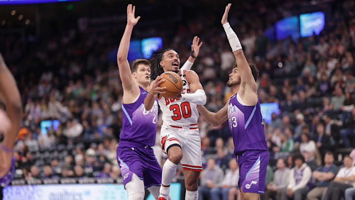Mar 17, 2025; Salt Lake City, Utah, USA;  Chicago Bulls guard Tre Jones (30) goes between Utah Jazz center Walker Kessler (24) and guard Johnny Juzang (33) and to the basket during the second half at Delta Center. Mandatory Credit: Chris Nicoll-Imagn Images