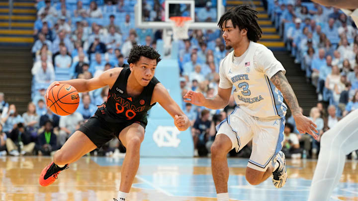 Mar 1, 2025; Chapel Hill, North Carolina, USA; Miami (Fl) Hurricanes guard Divine Ugochukwu (99) with the ball as North Carolina Tar Heels guard Elliot Cadeau (3) defends in the first half at Dean E. Smith Center. Mandatory Credit: Bob Donnan-Imagn Images Mar 1, 2025; Chapel Hill, North Carolina, USA; Miami (Fl) Hurricanes guard Divine Ugochukwu (99) with the ball as North Carolina Tar Heels guard Elliot Cadeau (3) defends in the first half at Dean E. Smith Center. Mandatory Credit: Bob Donnan-Imagn Images