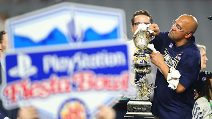 Penn State Nittany Lions head coach James Franklin jokingly pretends to clean the trophy as he celebrates after defeating the Washington Huskies in the 2017 Fiesta Bowl at University of Phoenix Stadium. 