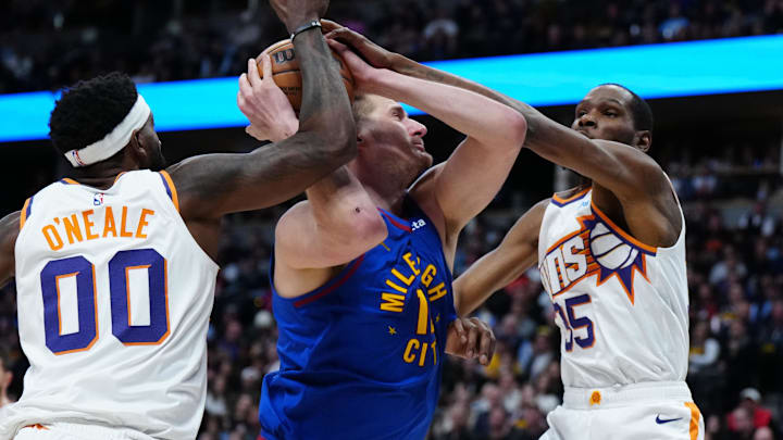 Mar 5, 2024; Denver, Colorado, USA; Phoenix Suns forward Kevin Durant (35) and forward Royce O'Neale (00) defend Denver Nuggets center Nikola Jokic (15) in the first half at Ball Arena. Mandatory Credit: Ron Chenoy-Imagn Images