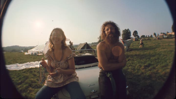 A couple smiles at the camera at Woodstock 1969