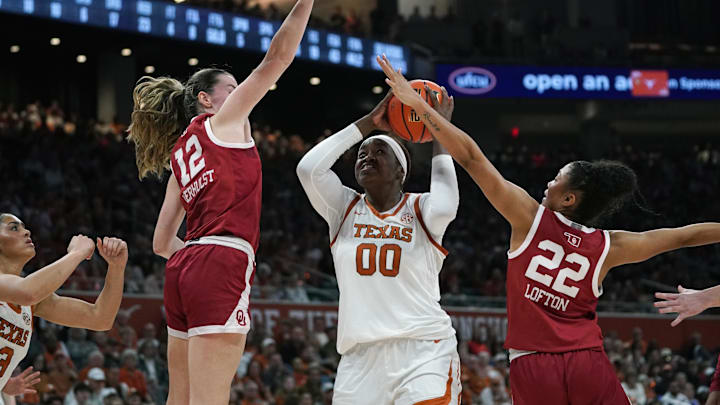Feb 1, 2026; Austin, Texas, USA; Texas Longhorns center Kyla Oldacre (00) makes a lay up against Oklahoma Sooners guard Payton Verhulst (12) and guard Keziah Lofton (22) during the second half at Moody Center. Mandatory Credit: Dustin Safranek-Imagn Images