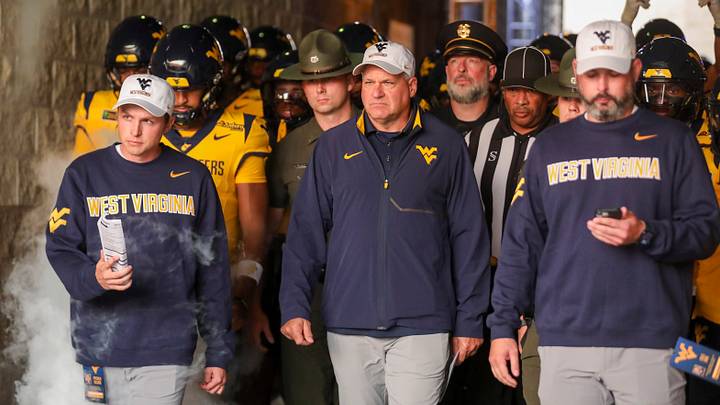 Sep 26, 2026; Morgantown, West Virginia, USA; West Virginia Mountaineers head coach Rich Rodriguez leads his team onto the field prior to their game against the Oklahoma State Cowboys at Milan Puskar Stadium. Mandatory Credit: Ben Queen-Imagn Images Sep 26, 2026; Morgantown, West Virginia, USA; West Virginia Mountaineers head coach Rich Rodriguez leads his team onto the field prior to their game against the Oklahoma State Cowboys at Milan Puskar Stadium. Mandatory Credit: Ben Queen-Imagn Images