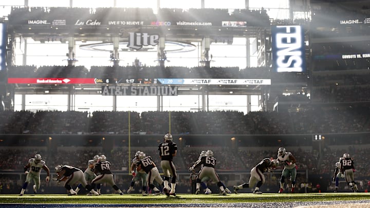 Oct 11, 2015; Arlington, TX, USA;  New England Patriots quarterback Tom Brady (12) throws in the pocket against the Dallas Cowboys as sun rays enter AT&T Stadium. Mandatory Credit: Matthew Emmons-Imagn Images