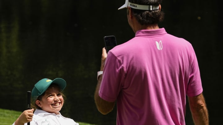 Apr 10, 2024; Augusta, Georgia, USA; Bubba Watson takes a picture of his daughter, Dakota, after she makes a putt.