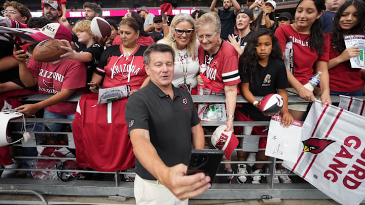 Arizona Cardinals owner Michael Bidwill takes a photo with fans after the team's training camp practice at State Farm Stadium in Glendale, Ariz., on Saturday, Aug. 3, 2024.