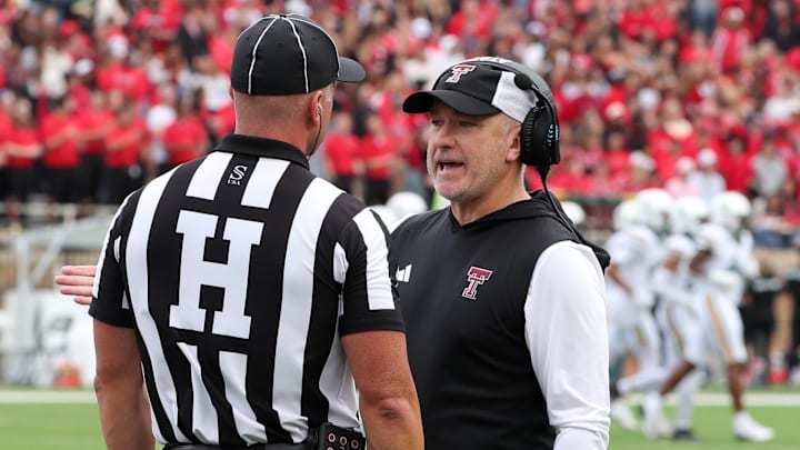 Oct 19, 2024; Lubbock, Texas, USA;  Texas Tech Red Raiders head coach Joey McGuire talks with Big 12 official. Mandatory Credit: Michael C. Johnson-Imagn Images