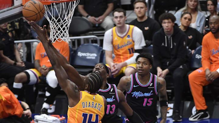 Mar 6, 2026; Charlotte, North Carolina, USA;  Charlotte Hornets forward center Moussa Diabate (14) drives in past the defense of Miami Heat center forward Bam Adebayo (13) during the first half at the Spectrum Center. Mandatory Credit: Sam Sharpe-Imagn Images