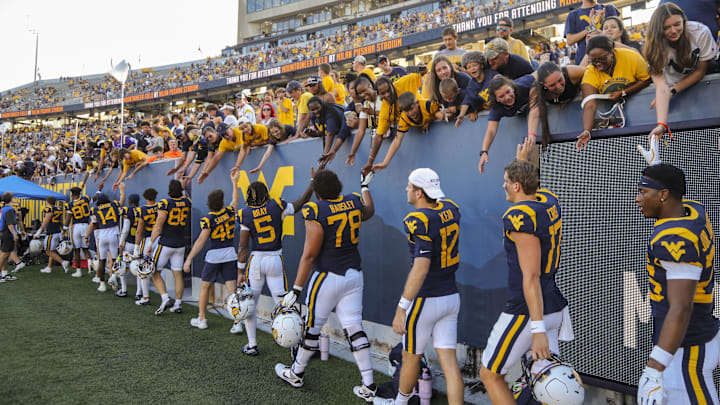 Sep 21, 2024; Morgantown, West Virginia, USA; West Virginia Mountaineers players celebrate with fans after defeating the Kansas Jayhawks at Mountaineer Field at Milan Puskar Stadium. Mandatory Credit: Ben Queen-Imagn Images Sep 21, 2024; Morgantown, West Virginia, USA; West Virginia Mountaineers players celebrate with fans after defeating the Kansas Jayhawks at Mountaineer Field at Milan Puskar Stadium. Mandatory Credit: Ben Queen-Imagn Images