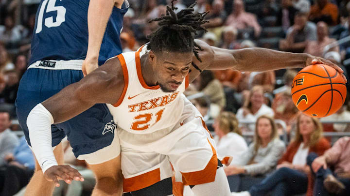 Texas forward Ze'Rik Onyema (21) drives toward the hoop around defense from Rice forward Max Fiedler