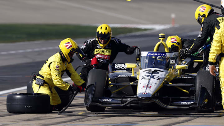 Sep 15, 2024; Nashville, Tennessee, USA;  Crew members for Andretti Autosport with Curb-Agajanian driver Colton Herta (26) of United States change tires during the Big Machine Music City Gran Prix at Nashville Superspeedway. Mandatory Credit: Butch Dill-Imagn Images