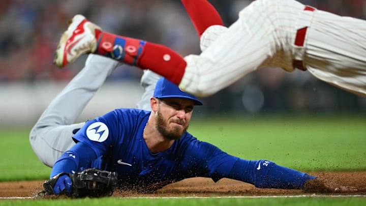 Sep 24, 2024; Philadelphia, Pennsylvania, USA; Chicago Cubs infielder Cody Bellinger (24) dives as Philadelphia Phillies catcher Garrett Stubbs (21) avoids the tag for an RBI bunt in the second inning at Citizens Bank Park. 