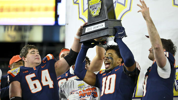 Dec 30, 2025; Nashville, TN, USA; Illinois Fighting Illini defensive back Miles Scott (10), quarterback Luke Altmyer (9) and offensive lineman Josh Kreutz (64) hoist the trophy after defeating the Tennessee Volunteers at Nissan Stadium. Mandatory Credit: Steve Roberts-Imagn Images
