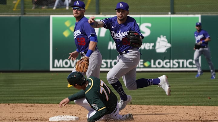 Feb 28, 2021; Mesa, Arizona, USA; Los Angeles Dodgers shortstop Jacob Amaya turns the double play while avoiding Oakland Athletics Tyler Soderstrom in the fifth inning at Hohokam Stadium. Mandatory Credit: Rick Scuteri-Imagn Images