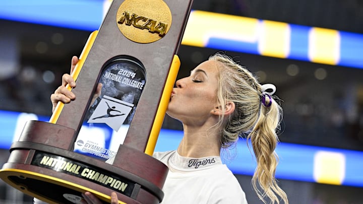 Apr 20, 2024; Fort Worth, TX, USA; LSU Tigers gymnast Olivia Dunne kisses the championship trophy after the LSU Tigers gymnastics team wins the national championship in the 2024 Womens National Gymnastics Championship at Dickies Arena. 