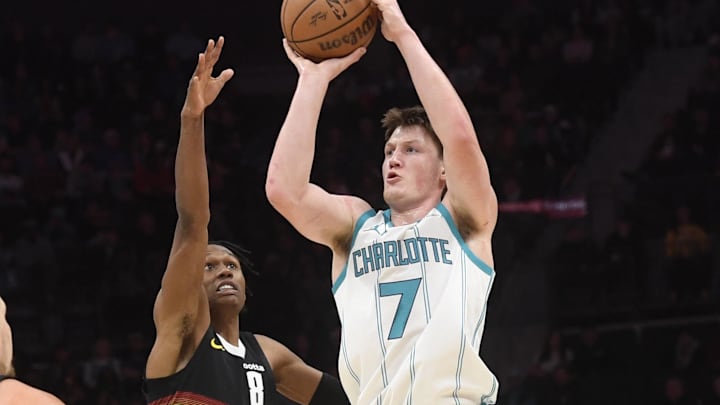 Dec 7, 2025; Charlotte, North Carolina, USA; Charlotte Hornets forward Kon Knueppel (7) shoots as he is defended by Denver Nuggets guard Peyton Watson (8) during the first half at the Spectrum Center. Mandatory Credit: Sam Sharpe-Imagn Images