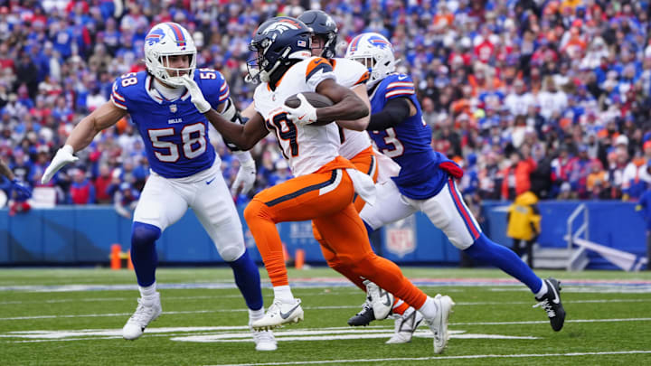 Jan 12, 2025; Orchard Park, New York, USA; Denver Broncos wide receiver Marvin Mims Jr. (19) runs for a gain as Buffalo Bills linebacker Matt Milano (58) defends during the second quarter in an AFC wild card game