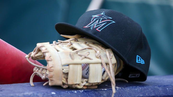 Apr 24, 2024; Atlanta, Georgia, USA; A detailed view of a Miami Marlins hat and glove in the dugout before a game against the Atlanta Braves at Truist Park. Mandatory Credit: Brett Davis-Imagn Images