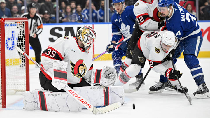 Mar 15, 2025; Toronto, Ontario, CAN;  Ottawa Senators goalie Linus Ullmark (35) makes a save as defensemen Artem Zub (2) and Thomas Chabot (72) hold back Toronto Maple Leafs forward Auston Matthews (34) in the third period at Scotiabank Arena. Mandatory Credit: Dan Hamilton-Imagn Images