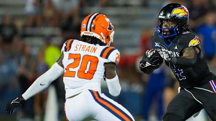 Sep 8, 2023; Lawrence, Kansas, USA; Kansas Jayhawks running back Devin Neal (4) runs the ball against Illinois Fighting Illini defensive back Tyler Strain (20) and defensive lineman Jer'Zhan Newton (4) during the second half at David Booth Kansas Memorial Stadium. Mandatory Credit: Jay Biggerstaff-Imagn Images