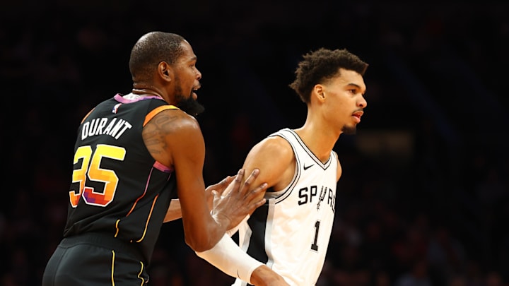 Dec 3, 2024; Phoenix, Arizona, USA; Phoenix Suns forward Kevin Durant (35) against San Antonio Spurs center Victor Wembanyama (1) in the first half of an NBA Cup game at Footprint Center. Mandatory Credit: Mark J. Rebilas-Imagn Images