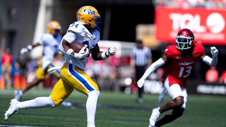 Pittsburgh Panthers running back Derrick Davis Jr. (34) runs downfield as Cincinnati Bearcats cornerback Logan Wilson (13) attempts to stop him in the third quarter of the College Football game at Nippert Stadium in Cincinnati on Saturday, Sept. 7, 2024. Pittsburgh Panthers running back Derrick Davis Jr. (34) runs downfield as Cincinnati Bearcats cornerback Logan Wilson (13) attempts to stop him in the third quarter of the College Football game at Nippert Stadium in Cincinnati on Saturday, Sept. 7, 2024.