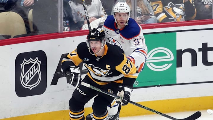Jan 9, 2025; Pittsburgh, Pennsylvania, USA;  Pittsburgh Penguins center Sidney Crosby (87) and Edmonton Oilers center Connor McDavid (97) chase the puck during the third period at PPG Paints Arena. Mandatory Credit: Charles LeClaire-Imagn Images