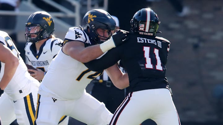 Nov 30, 2024; Lubbock, Texas, USA;  West Virginia Mountaineers offensive lineman Wyatt Milum (74) blocks Texas Tech Red Raiders defensive back Charles Esters III (11) in the first half at Jones AT&T Stadium and Cody Campbell Field. Mandatory Credit: Michael C. Johnson-Imagn Images