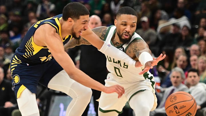 Dec 13, 2023; Milwaukee, Wisconsin, USA; Indiana Pacers guard Tyrese Haliburton (0) and Milwaukee Bucks guard Damian Lillard (0) reach for a loose ball in the first quarter at Fiserv Forum. Mandatory Credit: Benny Sieu-Imagn Images