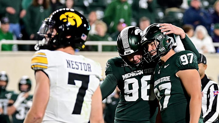 Oct 19, 2024; East Lansing, Michigan, USA;  Michigan State Spartans place kicker Jonathan Kim (97) celebrates with punter Ryan Eckley (96) as Iowa Hawkeyes defensive back John Nestor (7) watches Kim’s sixth field goal go through the uprights at Spartan Stadium. Mandatory Credit: Dale Young-Imagn Images