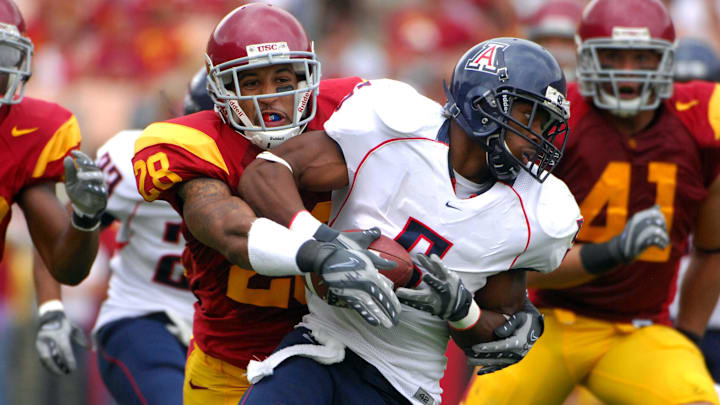 Oct 13, 2007; Los Angeles, CA; USA; Antoine Cason of Arizona (5) is tackled by Terrell Thomas of Southern California (28) on a punt return at the Los Angeles Memorial Coliseum. USC defeated Arizona 20-13. Mandatory Credit: Kirby Lee/Image of Sport-Imagn Images