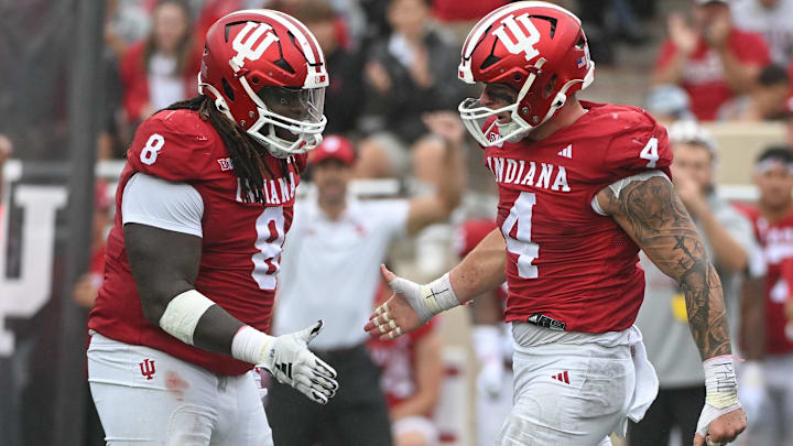 Indiana Hoosiers defensive lineman CJ West (8) and linebacker Aiden Fisher (4) celebrate after a defensive stop against Maryland at Memorial Stadium. 