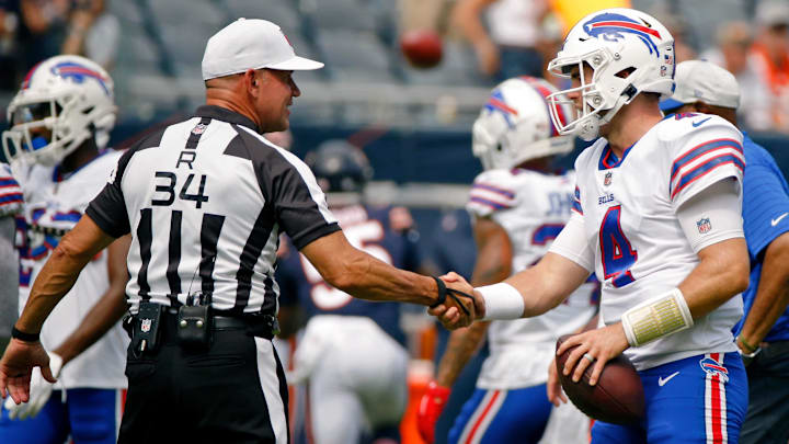Aug 21, 2021; Chicago, Illinois, USA; Buffalo Bills quarterback Jake Fromm (4) shakes hands with referee Clete Blakeman (34) during warmups before the game against the Chicago Bears at Soldier Field. Mandatory Credit: Jon Durr-Imagn Images